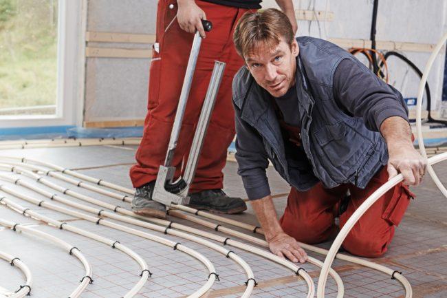 Installation eines wasserbeheizten Fußbodens auf einem Holzsockel